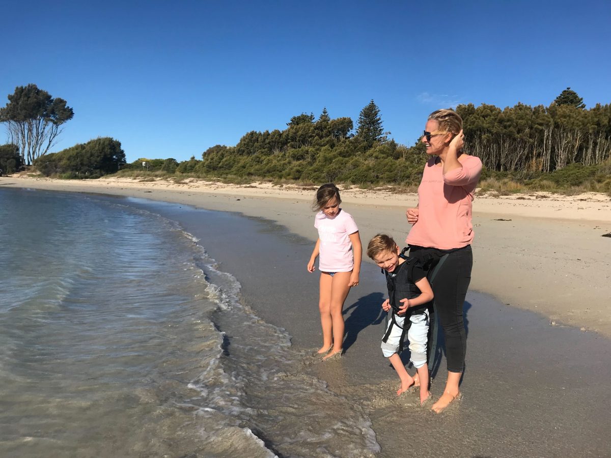 Image of Bree, holding her son Davidx via a brace, alongside her daughter Dylan at the beach.